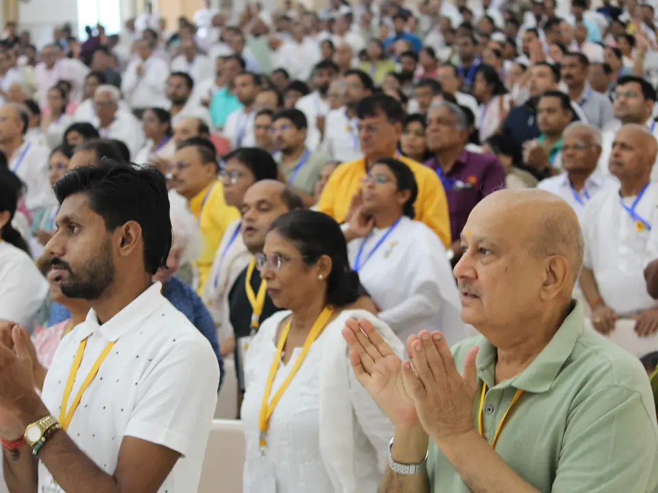 Delegates seated in the conference hall applauding