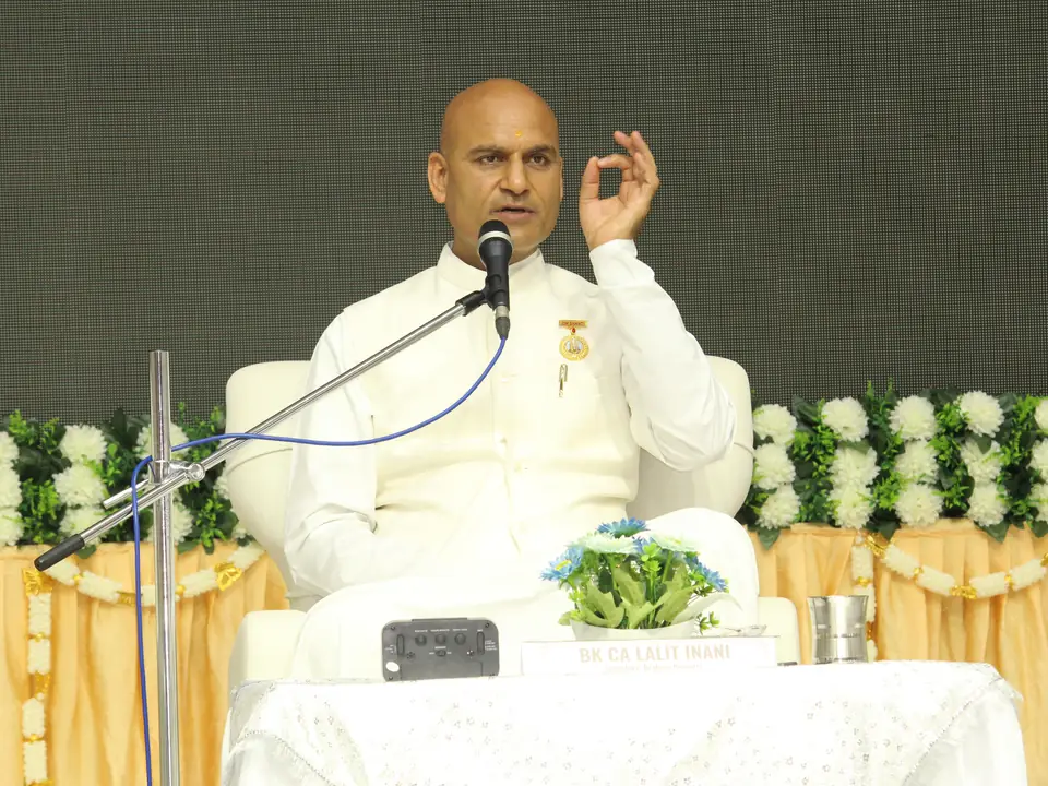 BK CA Lalit Inani seated on stage, speaking at a microphone