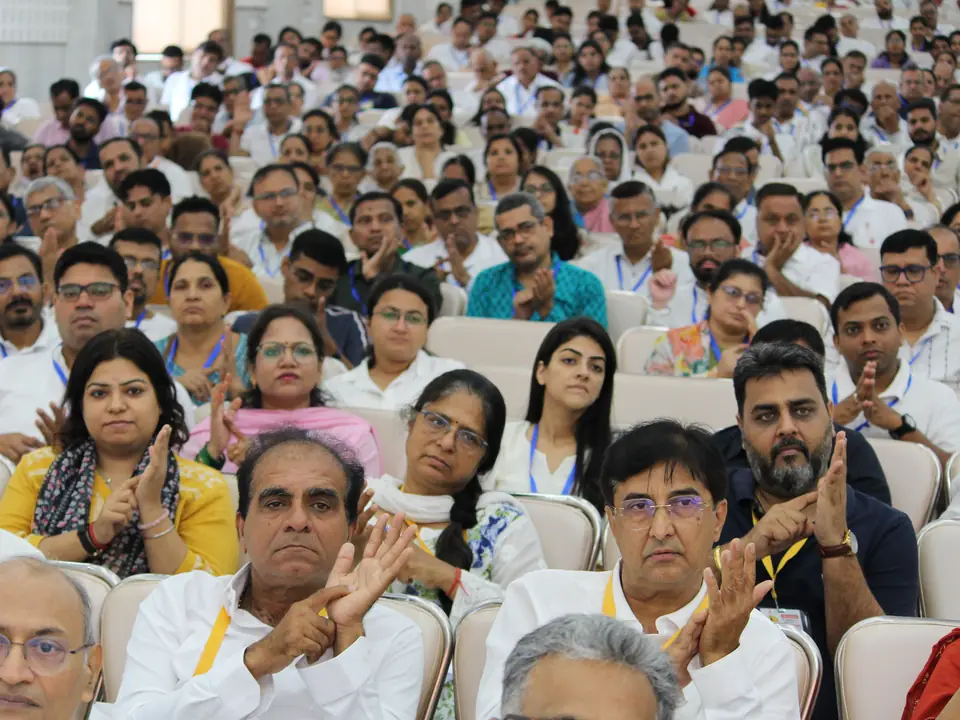 A packed hall of delegates listening during a session