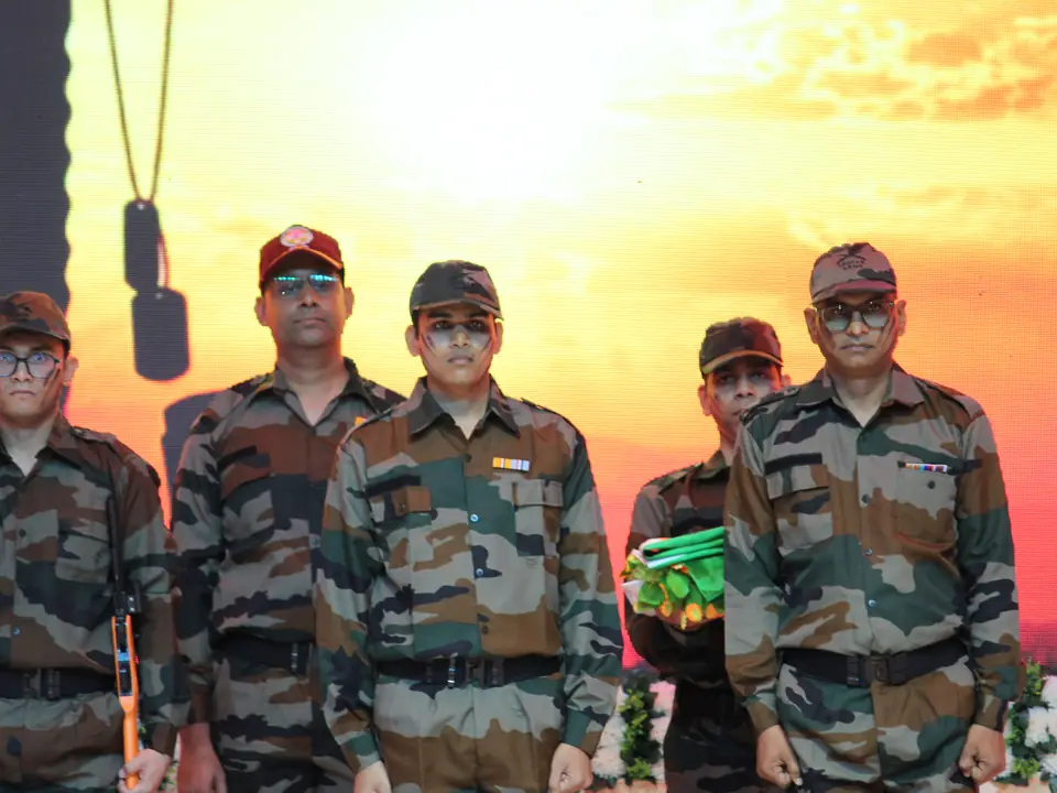 Performers in army uniform on stage before a sunrise backdrop