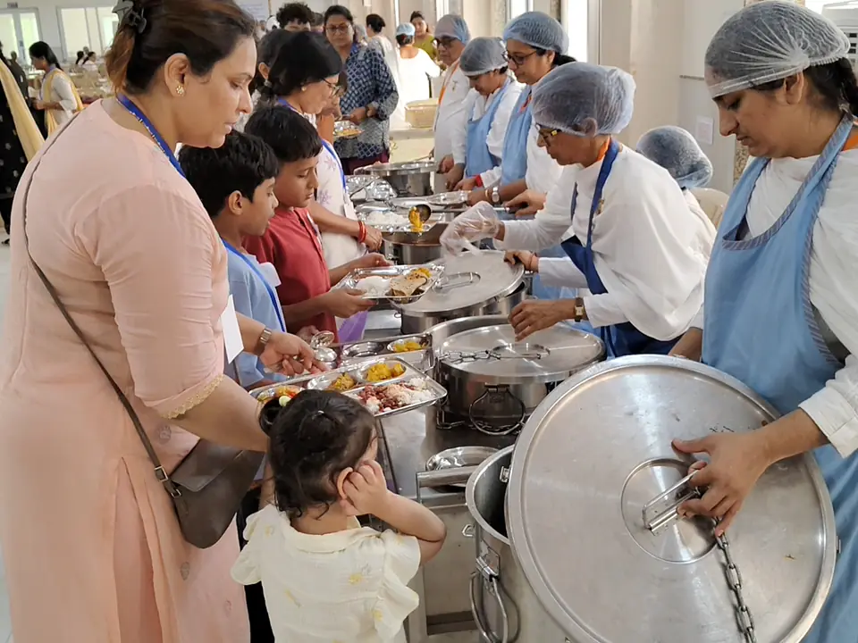 Volunteers serving food to participants in the dining hall